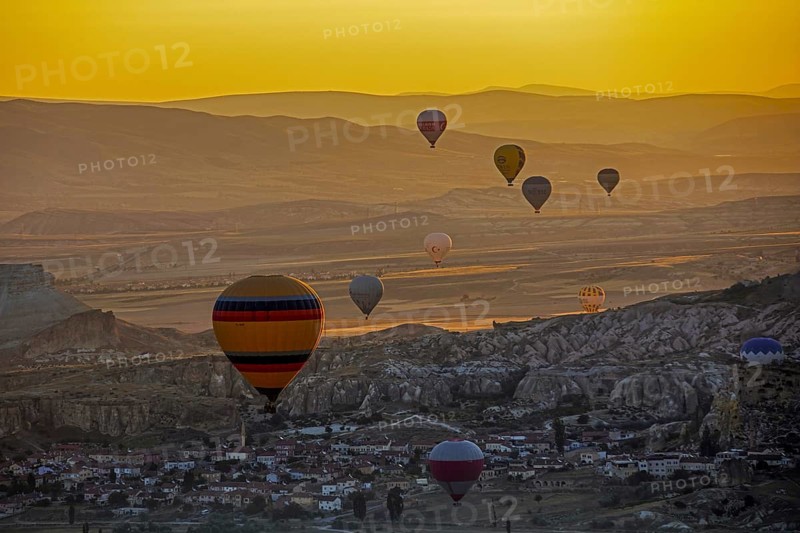Hot air balloons flying over the town Goereme in Cappadocia at sunrise