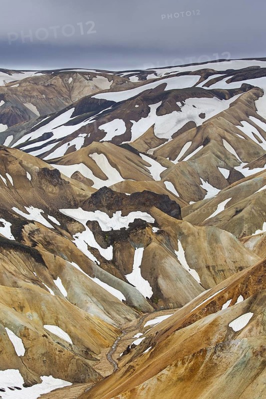 Sulphur coloured rhyolite mountains with patches of snow at Brennisteinsalda volcano near Landmannalaugar
