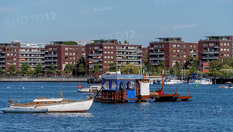 Illegally anchored houseboats in the Rummelsburg Bay with the residential houses on the Rummelsburg shore