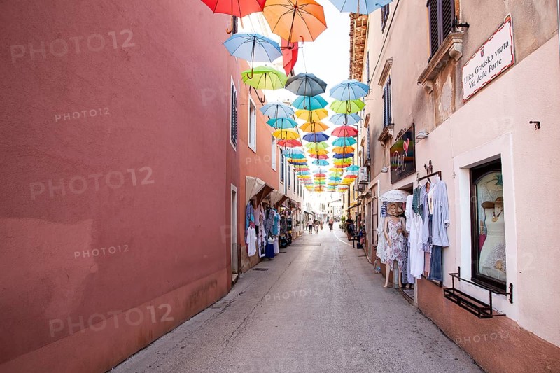Alley with colourful umbrellas suspended over a street