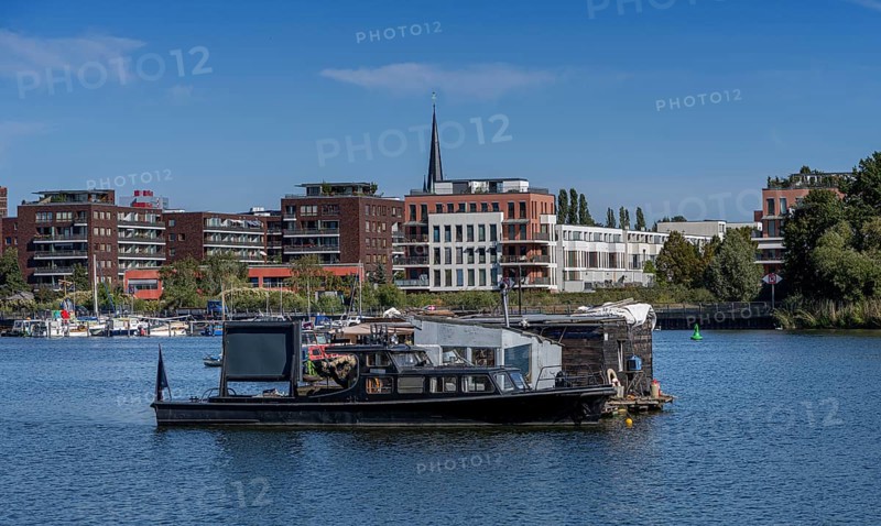 Illegally anchored houseboats in the Rummelsburg Bay with the residential houses on the Rummelsburg shore