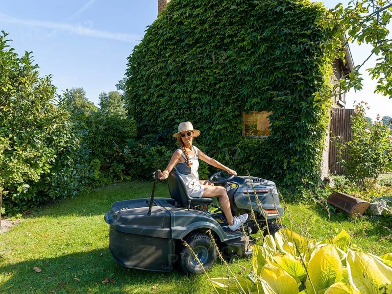 Woman driving lawn mower