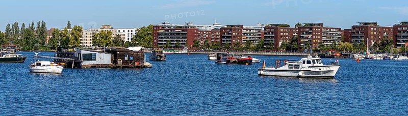Illegally anchored houseboats in the Rummelsburg Bay with the residential houses on the Rummelsburg shore