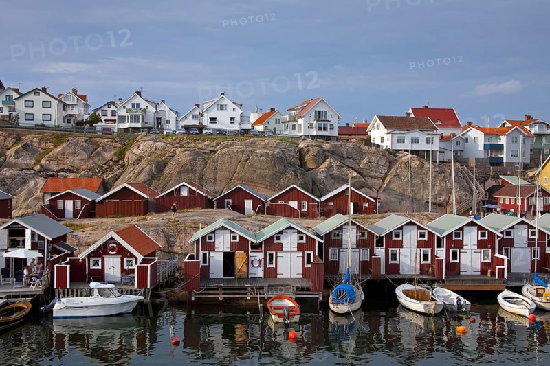 Colourful traditional fishing huts and boathouses along wooden pier at Smoegen