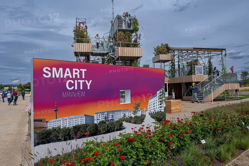 Sign saying Smart City Mannheim in front of viewing platforms on metal scaffolding overgrown with green plants at the Federal Horticultural Show
