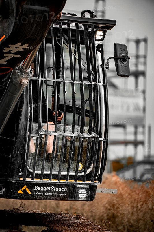 Black Liebherr crawler excavator excavating earth for house construction on building site