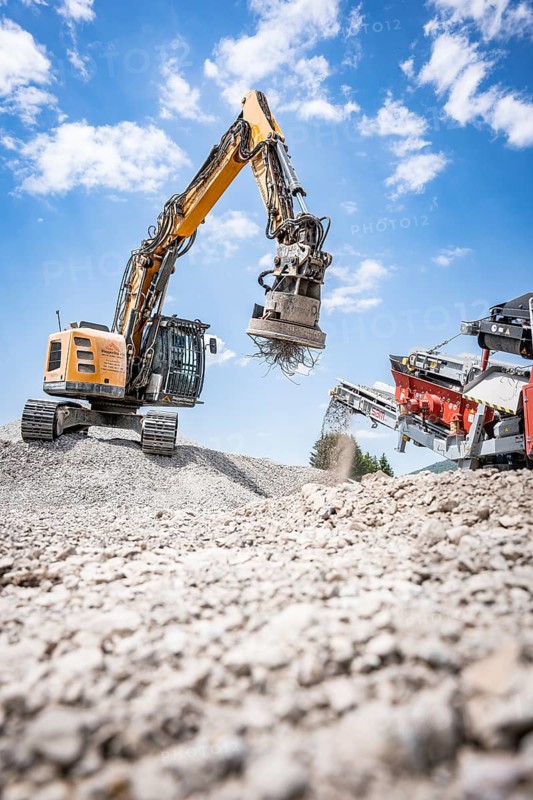 Yellow tracked excavator for demolition recycling on construction site