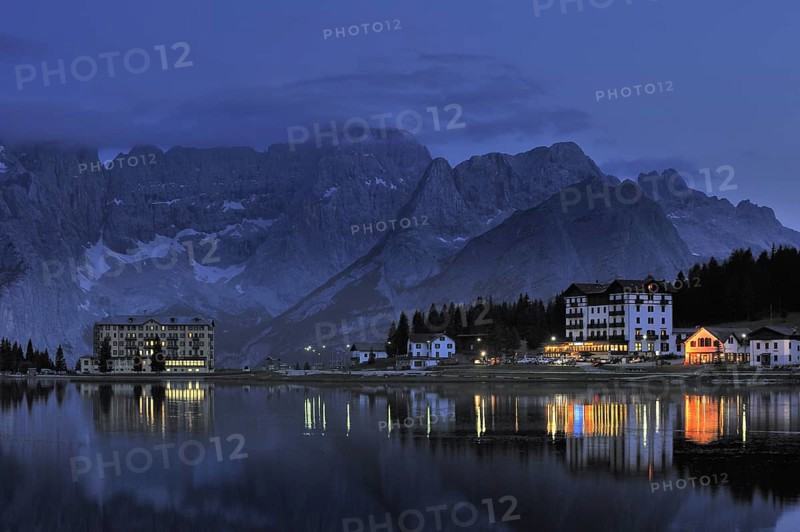 The mountain range Gruppo del Sorapis and hotels at night along lake Lago di Misurina in Auronzo di Cadore