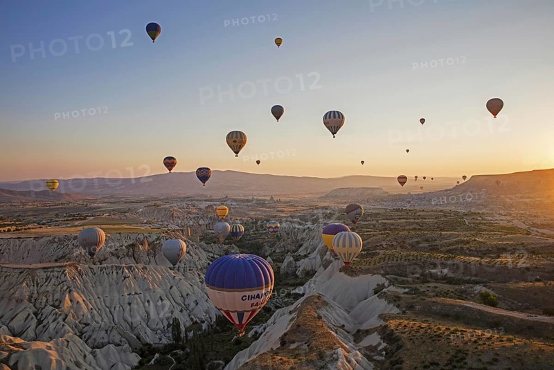 Hot air balloons flying over Cappadocia at sunrise