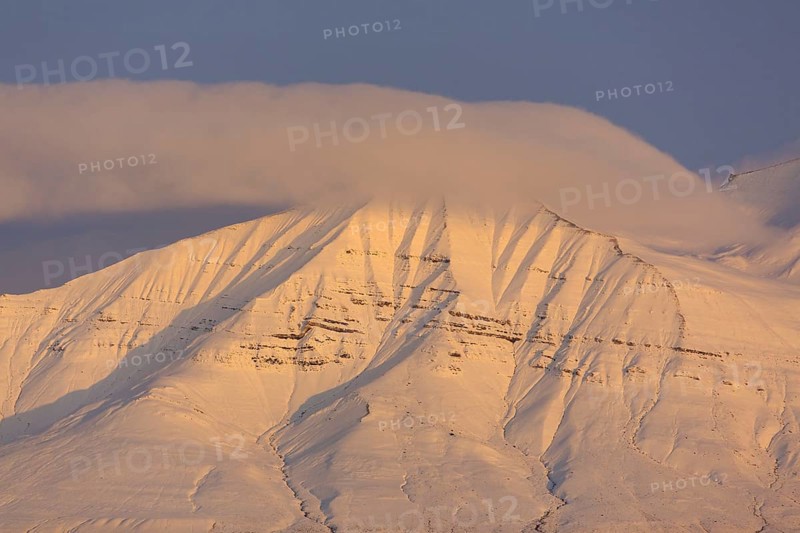 Snow covered mountain peak at sunset at Billefjorden