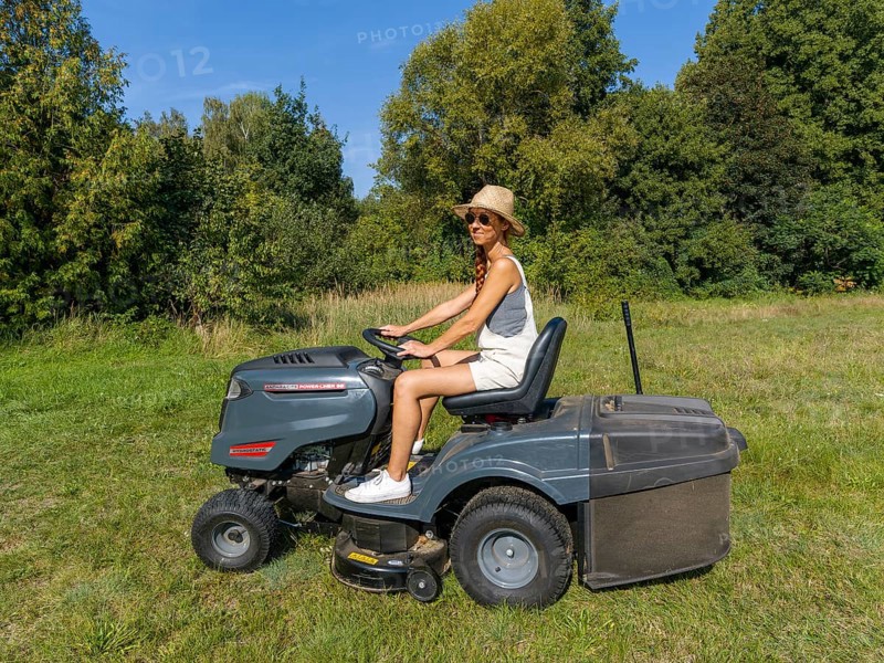 Woman driving lawn mower