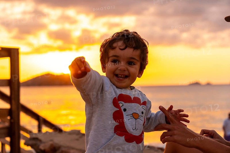 Boy laughing at sunset in Cala Comte beach on the island of Ibiza. Balearic