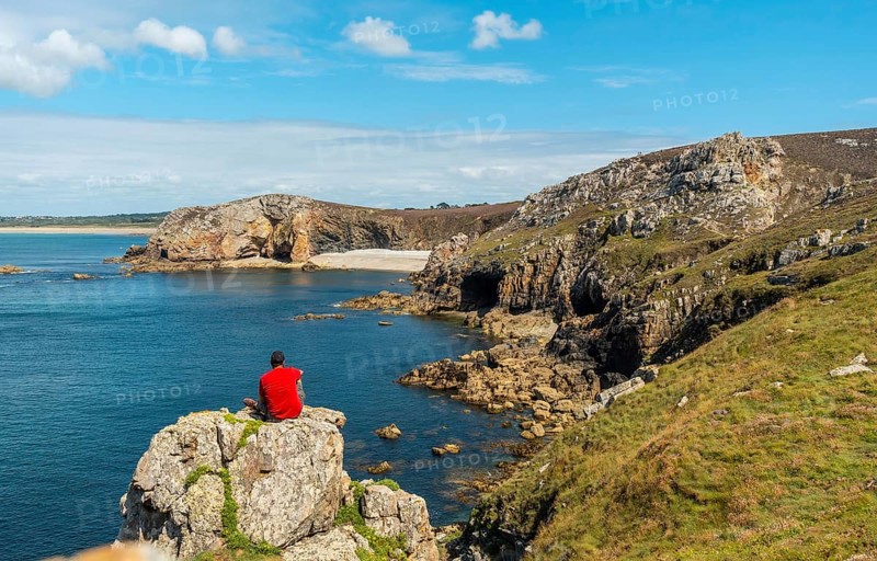 A young man in a red shirt on the coast enjoying the summer at Le Chateau de Dinan on the Crozon peninsula in French Brittany