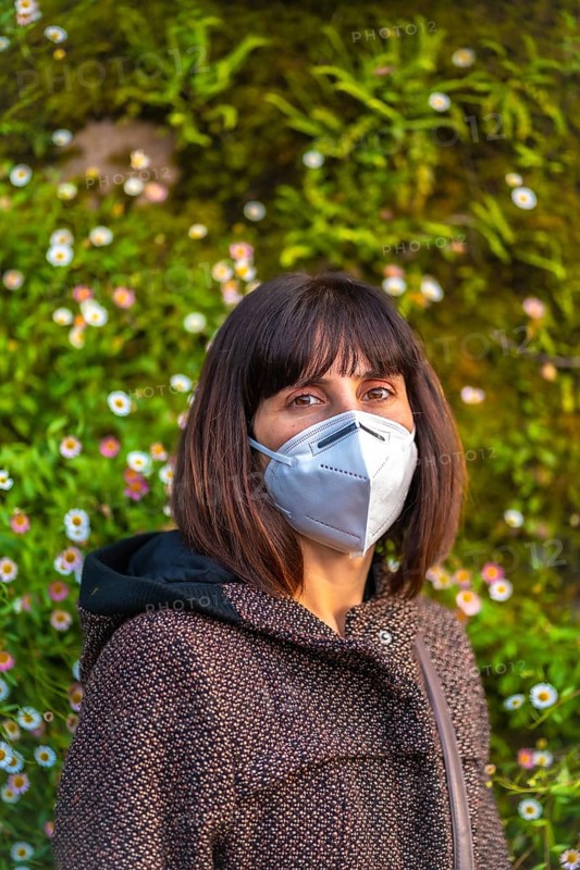 A young woman with a mask on her first walks in mistrust. First walks of the uncontrolled Covid-19 pandemic