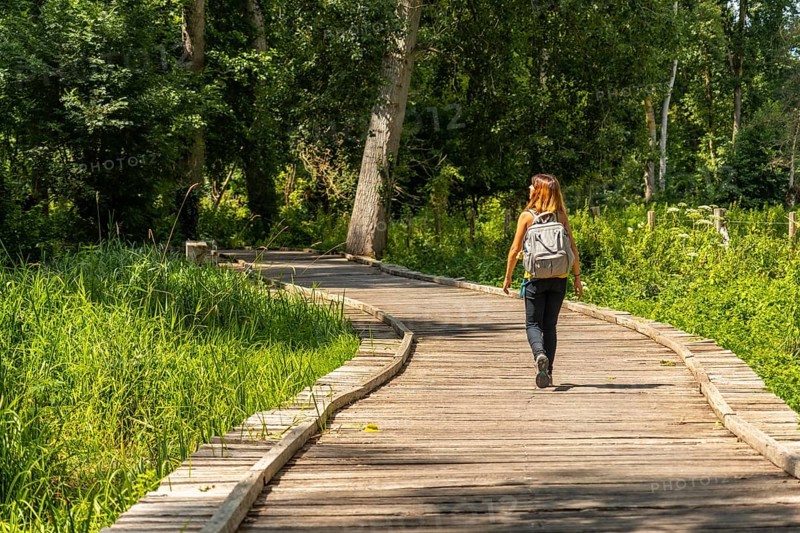A young woman on the footpath along a footbridge between La Garette and Coulon