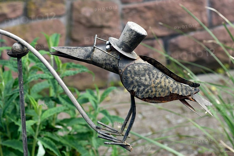 Raven as a tin figure in a garden