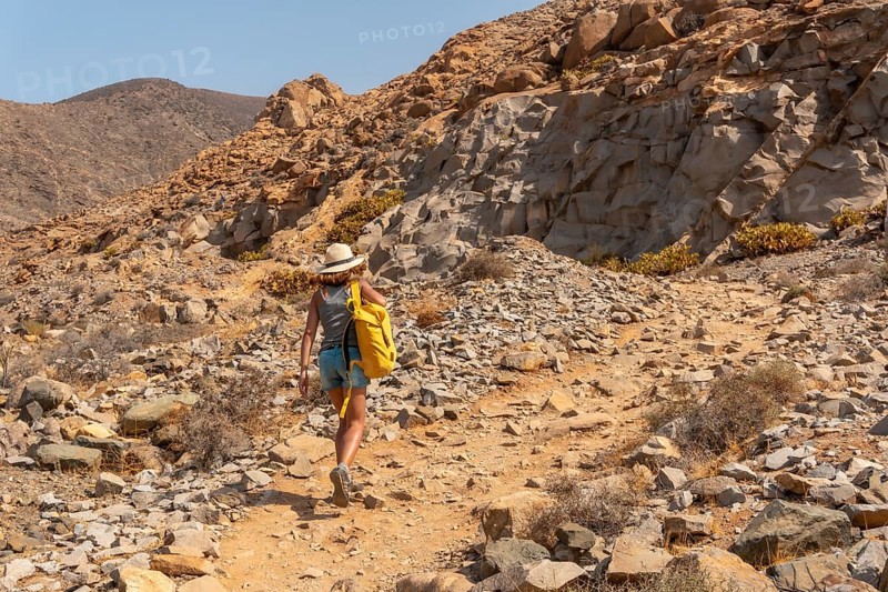A young woman walking along the canyon path towards the Mirador de la Penitas