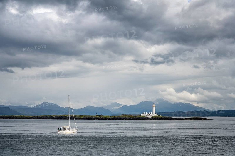 A sailing ship sails on Loch Linnhe past Lismore Lighthouse