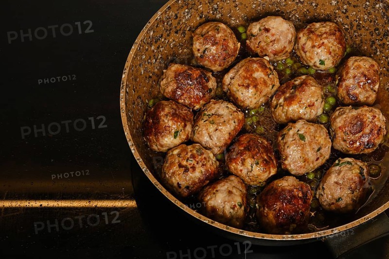 Scandinavian meatballs with green pea and cranberry jam in a frying pan