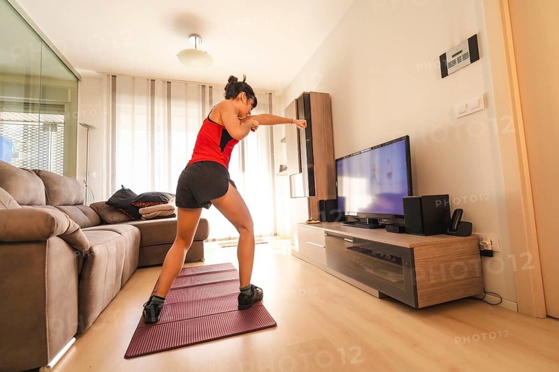 A young woman doing sports in her living room. Sport in the quarantine at home