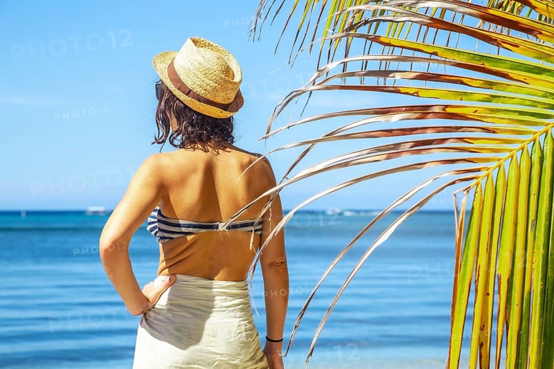 A young woman with a hat on West End beach on Roatan Island. Honduras