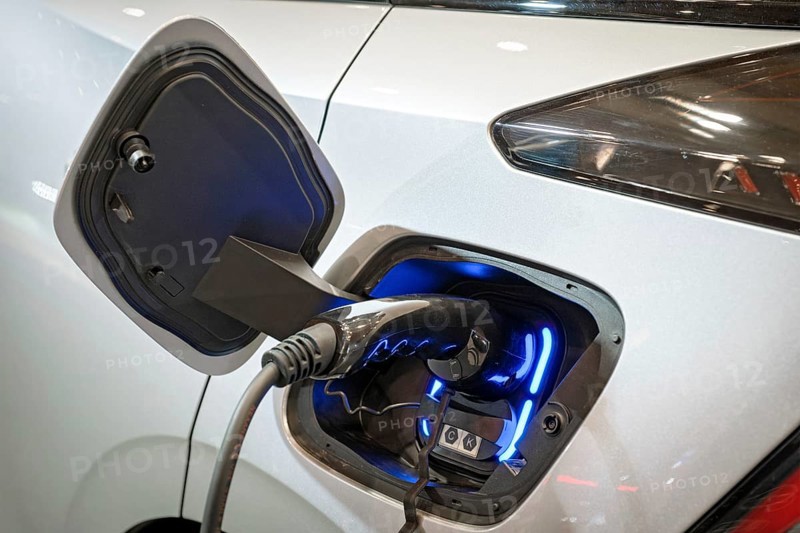 Charging port socket plug in modern electric vehicle EV car close up with charging cable. Environment ecology alternative green renewable clean sustainable energy zero emission concept