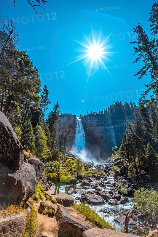 A brunette tourist with black T-shirt in Vernal Falls from the bottom looking at the waterfall. California