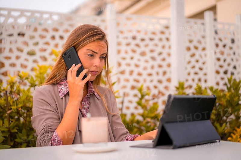 Portrait of an executive and businesswoman having breakfast in a restaurant talking on the phone and a tablet