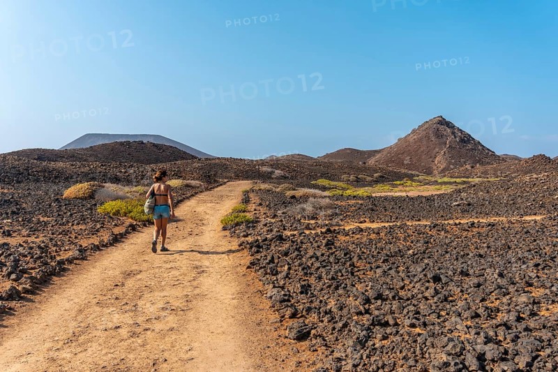 A young woman on the path to the north of the Isla de Lobos
