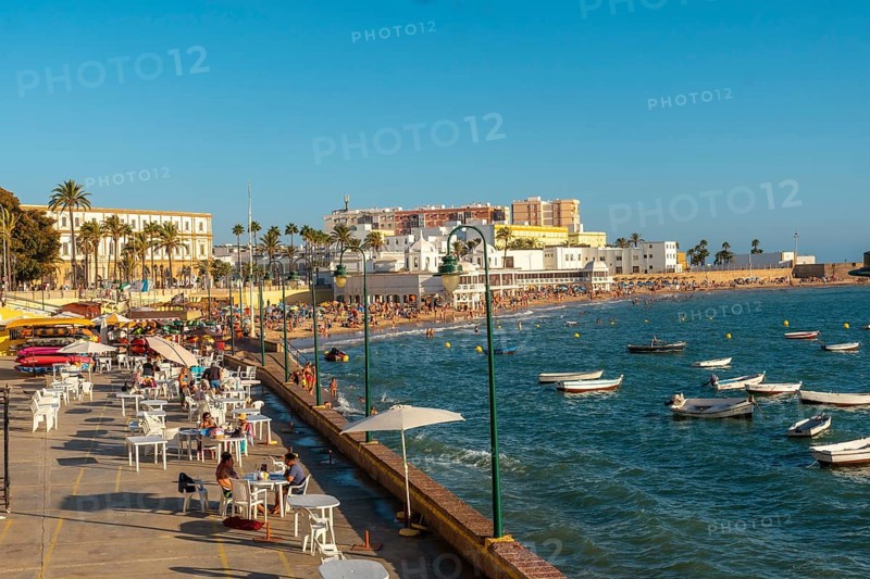 La Caleta beach full of tourism in the summer sunset of the city of Cadiz. Andalusia