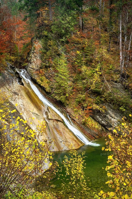 Schleierfaelle at the entrance to the Starzlachklamm gorge in autumn. Trees in autumn foliage. Long exposure. Allgaeu