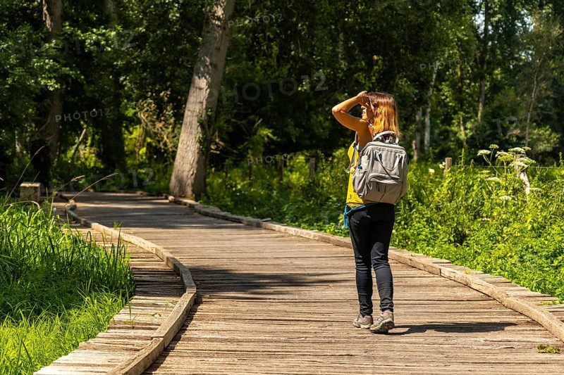 A young woman trekking on the footpath along a footbridge between La Garette and Coulon