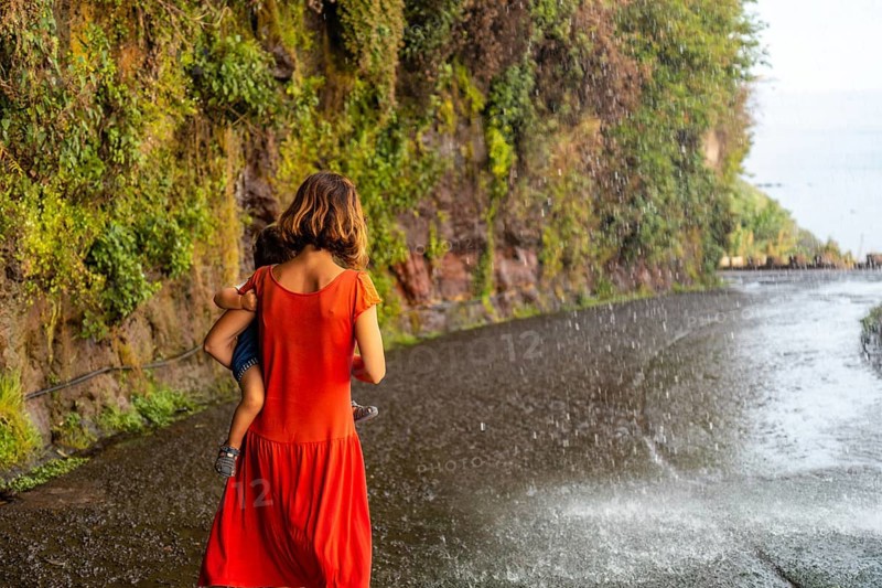 A mother with her son in a red dress at Anjos Waterfall
