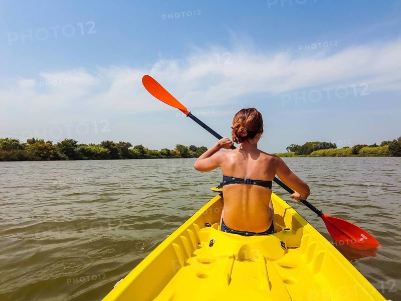 A young woman in the canoe canoeing in a natural park in Catalonia