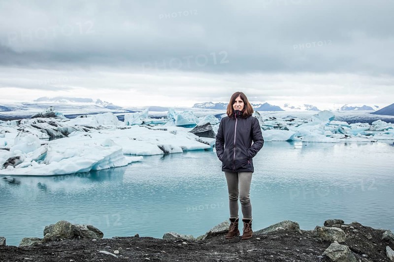 A cwoman with a backpack looking at the Jokulsarlon Ice Lake in the golden circle