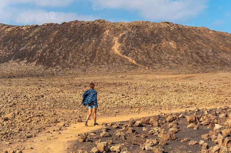 A young woman on the trail to the Crater of the Calderon Hondo volcano near Corralejo