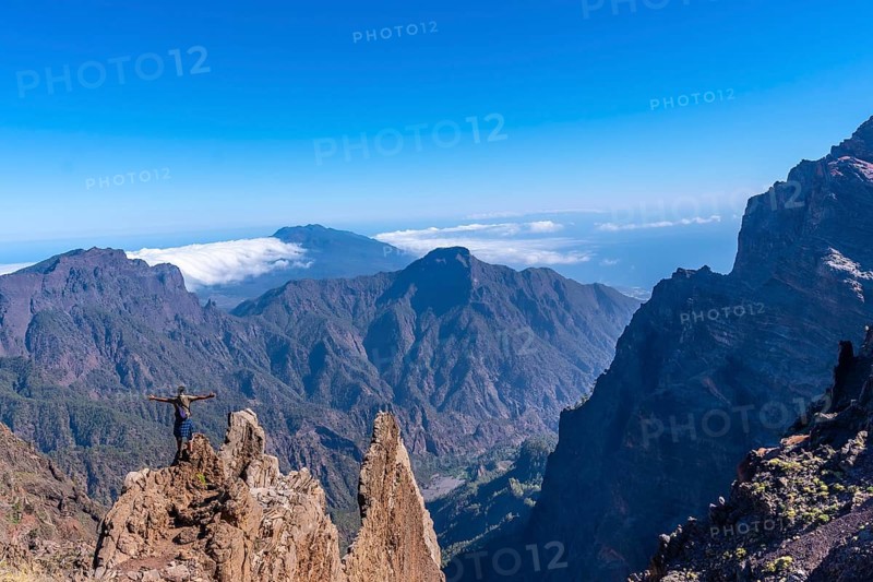 A young man after finishing the trek at the top of the volcano of Caldera de Taburiente near Roque de los Muchachos looking at the incredible landscape