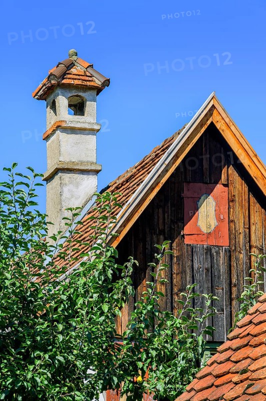 Pointed gable with wooden facade and brick chimney in the Farm Museum