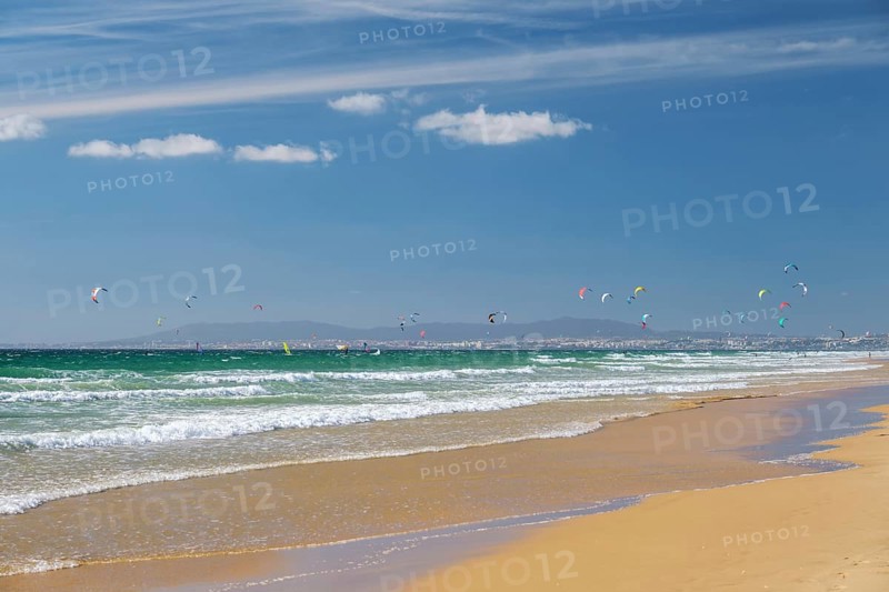 Kiteboarding kitesurfing kiteboarder kitesurfer kites on the Atlantic ocean beach at Fonte da Telha beach