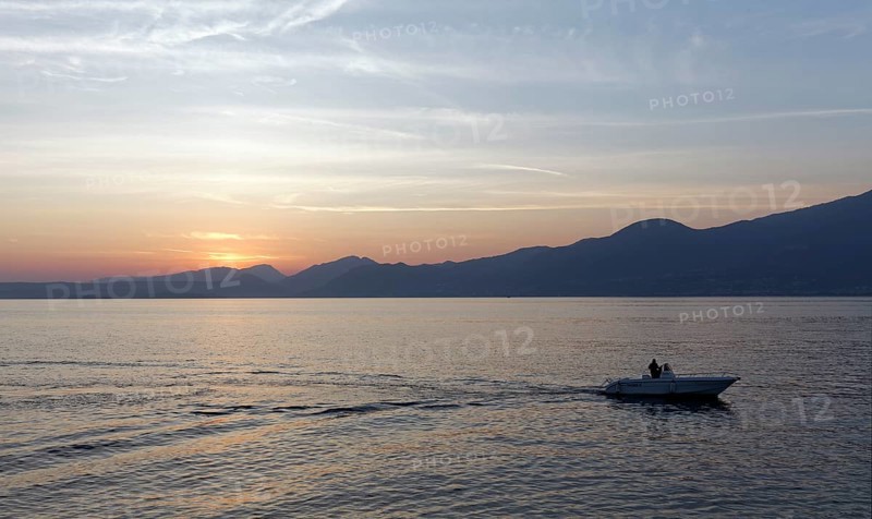 Single motorboat sailing on Lake Garda at Torri del Benaco