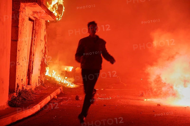 Young man runs through pyrotechnics