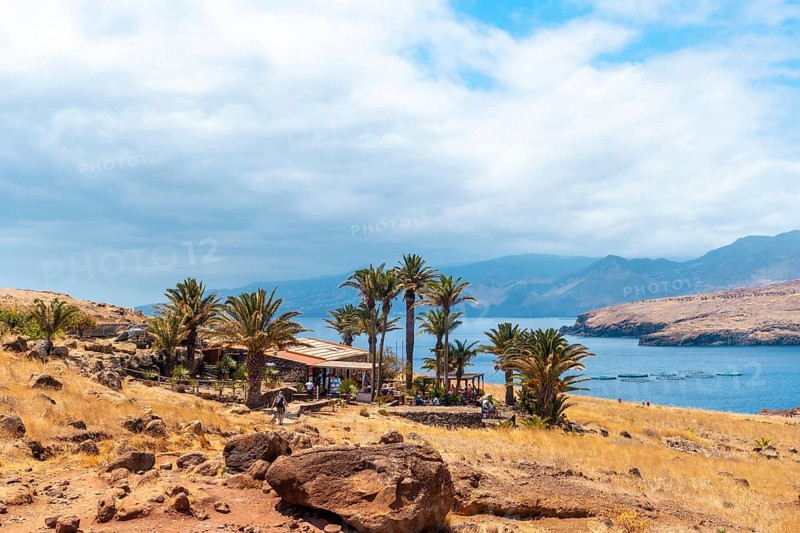 House and bar at the end of the path of Ponta de Sao Lourenco with palm trees in summer