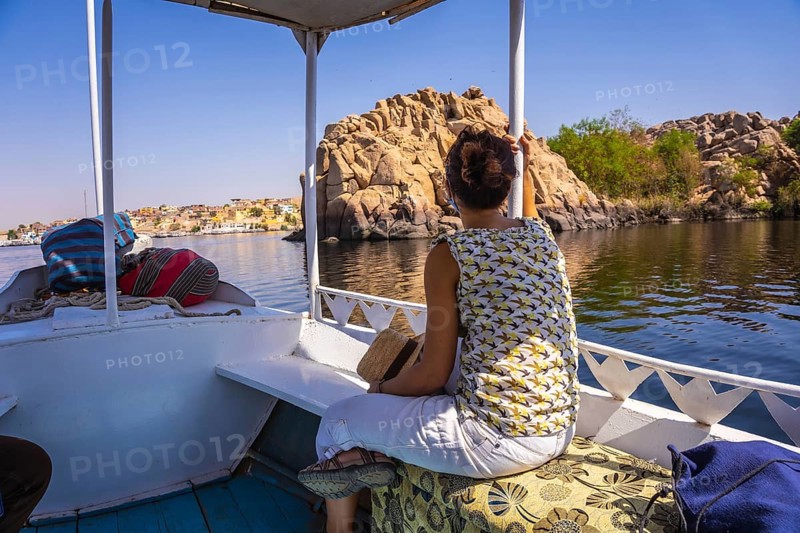 A young woman traveling by boat on the River Nile to the Philae temple dedicated to Isis