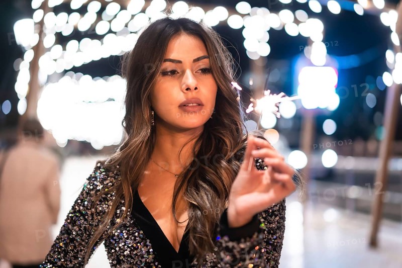 Winter lifestyle at Christmas. Brunette Caucasian girl in a fashionable dress with sequins