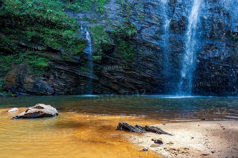 Waterfalls trickling down rocks into a small lake in Minas Gerais
