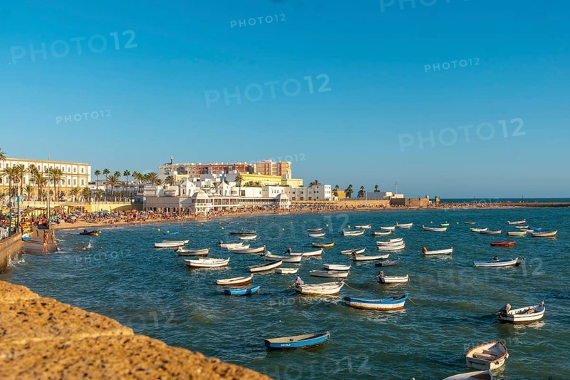 La Caleta beach full of tourism in the summer sunset of the city of Cadiz. Andalusia