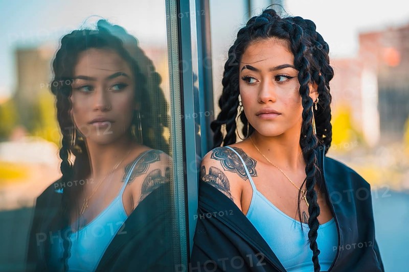 Urban session. Young woman of black ethnicity with long braids and with tattoos