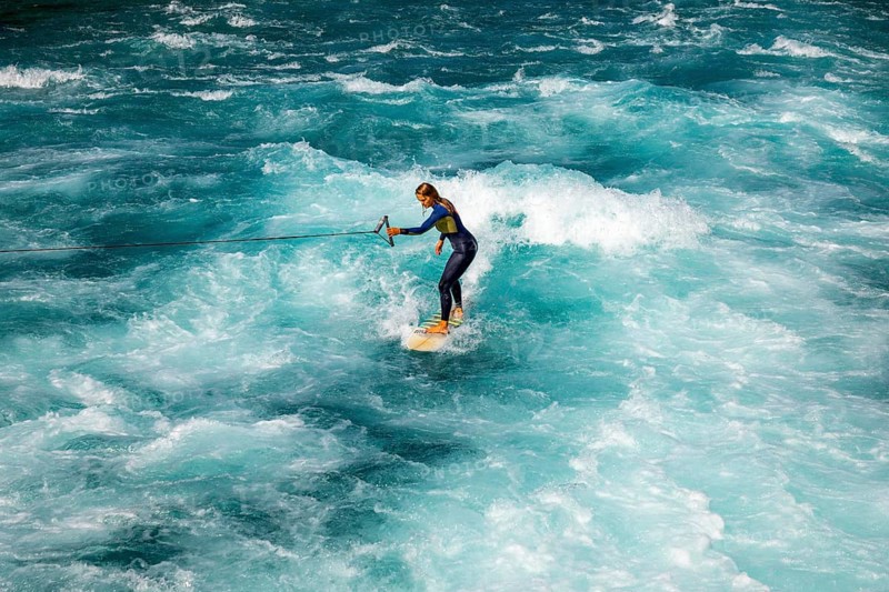 Surfer Surfing the Wave on River Aare in City of Thun in a Sunny Summer Day in Thun