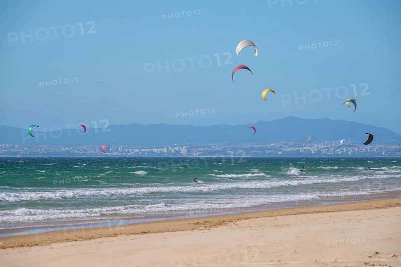 Kiteboarding kitesurfing kiteboarder kitesurfer kites on the Atlantic ocean beach at Fonte da Telha beach