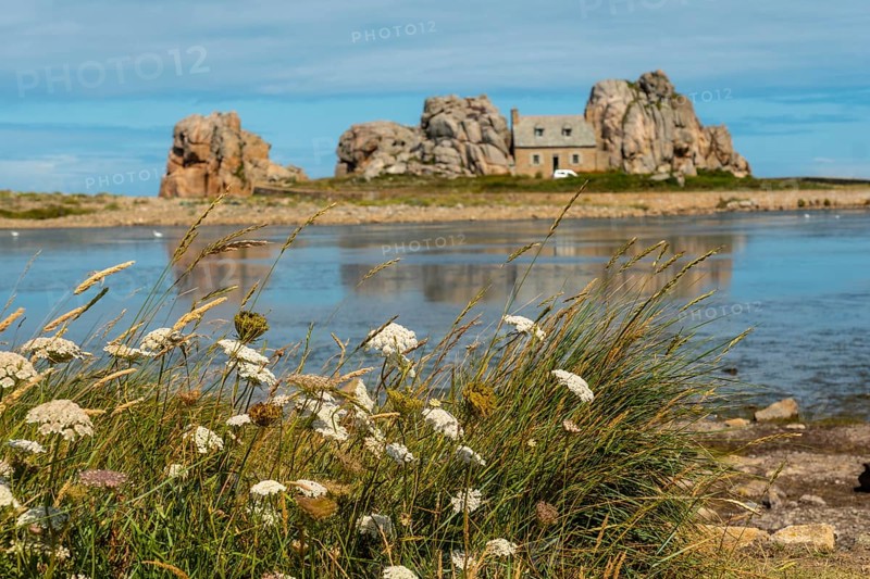 House between rocks next to a beautiful lake